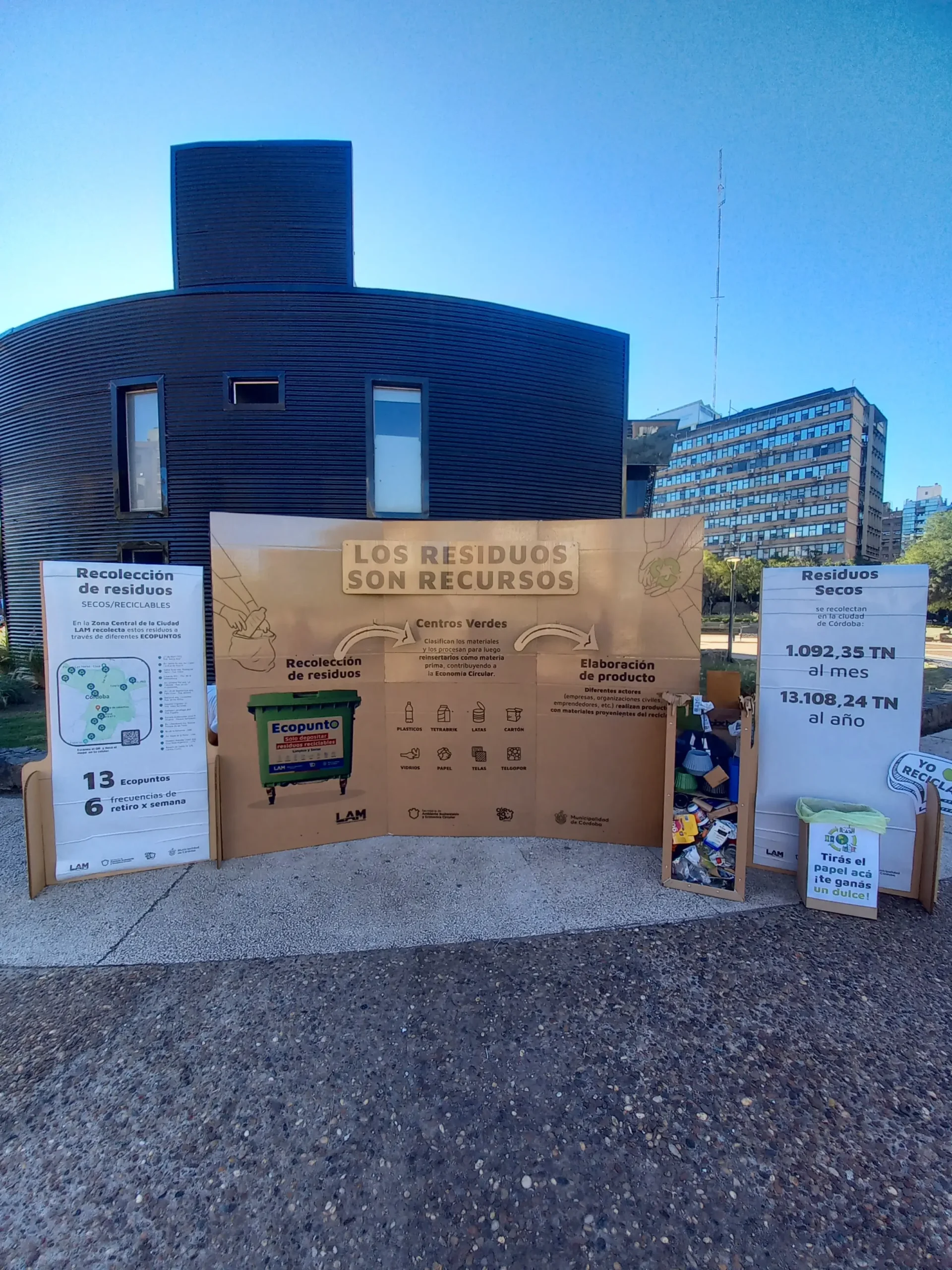 Stand de cartón de la empresa LAM para el Día de la Tierra en Córdoba, con cartelería informativa sobre ecocanje, economía circular y estadísticas de recolección de residuos secos.